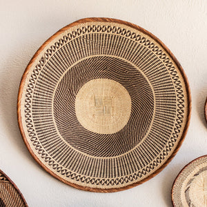 Woven basket with geometric pattern on a light background