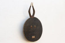 Decorative wall mask with circular design and antler-like extensions on a white background