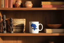 Mug with 'Love Africa' design on a wooden shelf with books and decorative items.