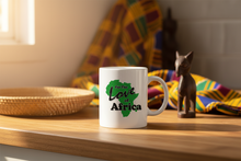 White mug with 'For the Love of Africa' design on a wooden surface with decorative items.
