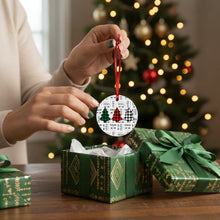 Person holding a Christmas ornament with a decorated tree design, surrounded by green gift boxes and a festive background.
