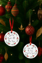 Two religious Christmas ornaments with text on a decorated tree.