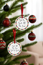 Decorative Christmas ornaments with motivational phrases on a tree.