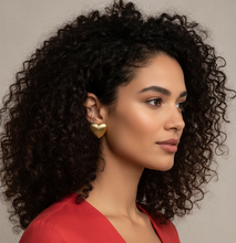 Woman with curly hair wearing a red top against a neutral background