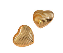 Gold heart-shaped earrings on a white background