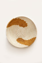 Woven basket with white gold spiral circle pattern on a white background