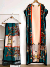 Kaftan dress with scarf with intricate patterns on hangers against a white background