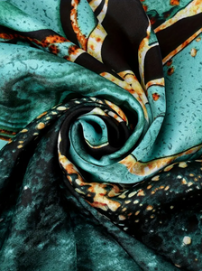 Close-up of patterned fabric with teal, black, and orange colors.