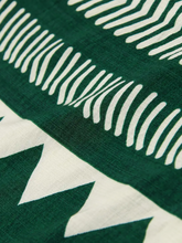 Close-up of a green fabric with white geometric patterns