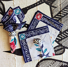 Decorative cotton fabric dinner napkins with intricate floral patterns on a textured surface