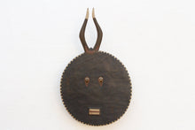 Decorative wall mask with circular design and antler-like extensions on a white background