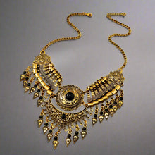 Decorative gold necklace with black accents on a wooden surface