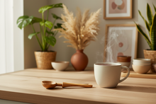 Steaming mug on a wooden table with plants and decor in the background