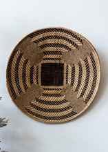 Woven basket with a geometric pattern on a white background