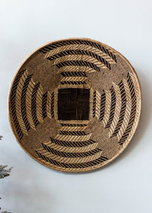 Woven basket with a geometric pattern on a white background