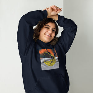 A person wearing a navy blue hoodie with an African pattern, smiling and raising their hands with hoodie over their head.
