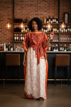woman wearing a orange kaftan dress at a wine bar.