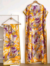 Floral-patterned dress and scarf on hangers against a white background