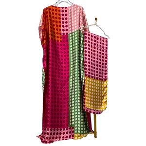 Colorful polka dot dress on a hanger against a white background
