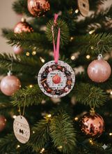 Decorative pink ornament on a Christmas tree with pink and gold ornaments.