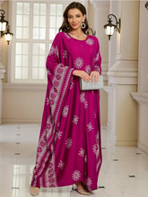 Woman wearing a magenta embroidered dress in an elegant interior setting