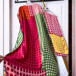 Colorful polka dot fabric on a hanger against a white door.
