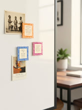 Colorful fridge magnets on a whiteboard in a home.