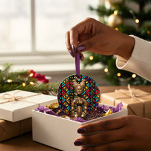 Decorative ornament with geometric African design held by a hand in front of Christmas tree and presents.