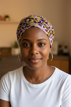 Woman wearing a patterned headscarf and white shirt indoors