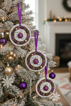 Decorative Christmas ornaments on a tree with a fireplace in the background