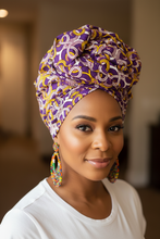 Woman wearing a colorful headwrap and earrings indoors