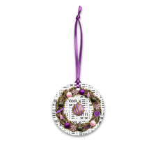 Decorative ornament with a wreath design and purple ribbon on a white background