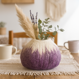 Purple and white wool vase with dried plants on a table with a blurred background