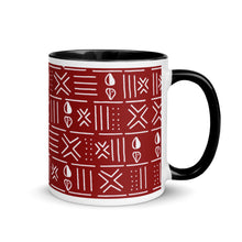 A red and white ceramic coffee mug with a mud cloth-inspired geometric pattern and black accents on the rim and handle.