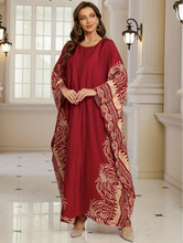 Woman wearing a red dress with floral patterns in an elegant interior setting