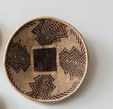 Woven basket with geometric patterns on a light gray background