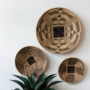 Three woven baskets with geometric patterns on a white background