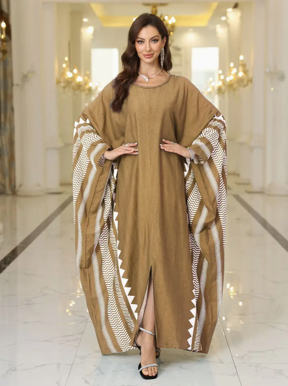 Woman wearing a brown tan dress with patterned sleeves in an elegant interior setting