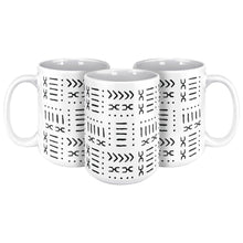 Three white and black coffee mugs with an African pattern