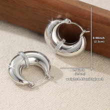Silver hoop earrings on a textured surface with measurements and weight displayed.