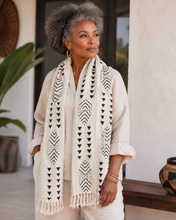 soft white woven fabric scarf with black African pattern worn on a mid 50's African American woman.