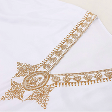 White fabric with gold embroidery on a white background