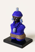 Decorative figurine with blue beaded outfit on a white background