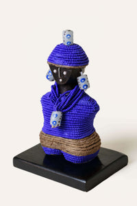 Decorative figurine with blue beaded outfit on a white background