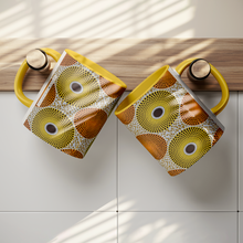 two yellow orange african pattern coffee mugs on hooks