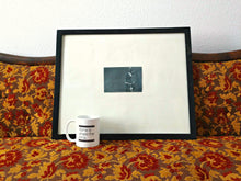 art coffee mug on a patterned sofa with artwork
